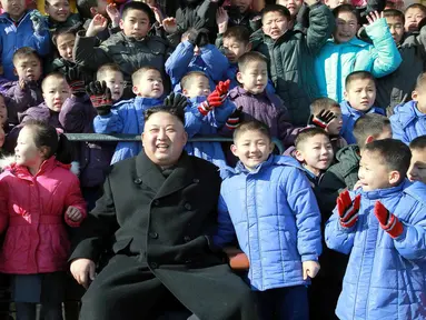  Pemimpin Korut, Kim Jong Un foto bersama dengan anak-anak yatim saat mengunjungi Sekolah Dasar Anak Yatim di Pyongyang, Korea Utara (2/2). (AFP Photo / KCNA VIA KNS / STR)