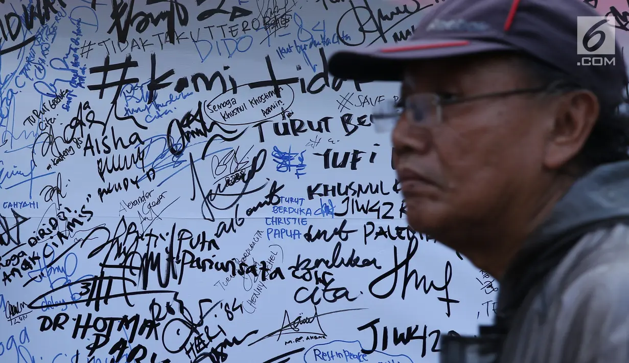 Pengunjung melintas di depan banner tulisan dukungan buat Polri pasca kerusuhan di Rutan cabang Salemba Mako Brimob saat acara Car Free Day di Kawasan Bundaran Hotel Indonesia, Jakarta, Minggu (13/5). (Liputan6.com/Helmi Fithriansyah)