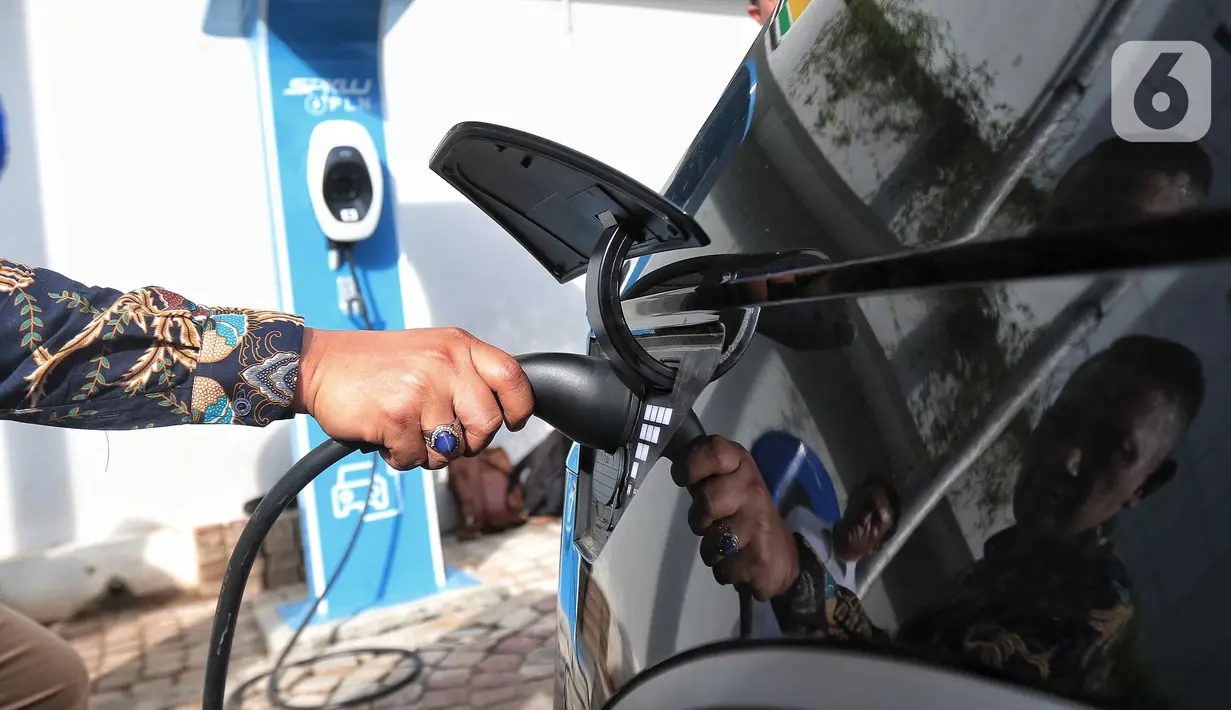 Sekjen DPR Indra Iskandar mengisi daya mobil listrik merek 'Hyundai Ioniq 5' di halaman Kompleks DPR RI, Jakarta, Jumat (30/9/2022). Sebanyak 55 unit mobil tersebut akan digunakan para delegasi kegiatan 8th G20 Parliamentary Speakers’ Summit (Parliamentary20/ P20) pada 5-7 Oktober 2022 mendatang. (Liputan6.com/Angga Yuniar)