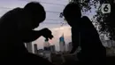 Anak-anak dengan latar gedung bertingkat menikmati makanan di Jakarta, Sabtu (19/3/2022). Bank Indonesia (BI) memperkirakan pertumbuhan ekonomi Indonesia akan meningkat lebih tinggi, pada kisaran 4,7 persen hingga 5,5 persen, dari pertumbuhan 3,69 persen pada 2021. (Liputan6.com/Angga Yuniar)