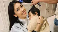 Aliya Rajasa Baskoro Yudhoyono saat menggendong putrinya yang tertidur saat potong rambut. (dok. Instagram @ruby_26/https://www.instagram.com/p/Bsmfol8giGq/Putu Elmira)