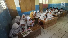 Murid-murid kelas V melakukan kegiatan belajar pada meja yang diubah menjadi kursi dan tempat belajar di SDN Kertajaya 2, Rumpin, Bogor (22/7/2019). Sudah lebih dari tiga tahun mereka belajar  pada fasilitas yang minim. (merdeka.com/Arie Basuki)