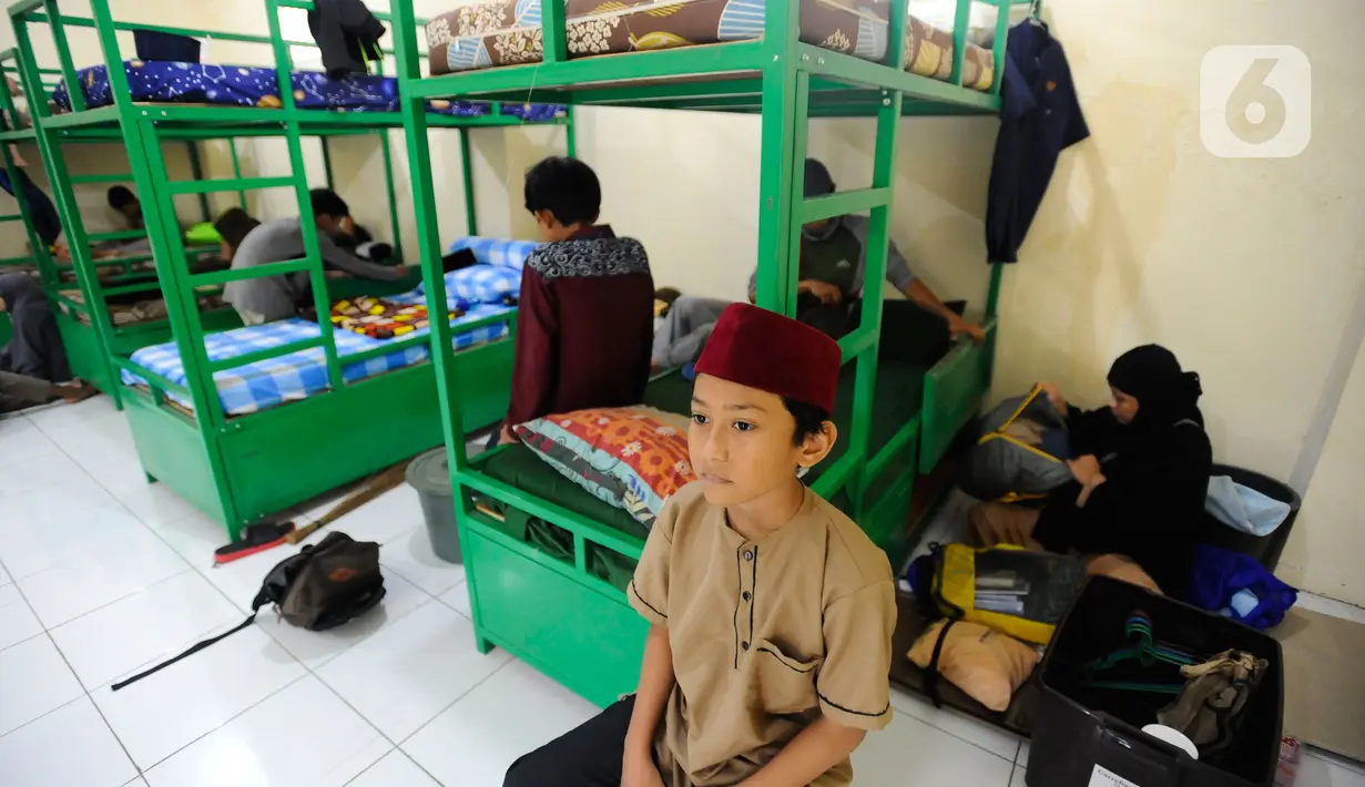 Orang tua santri membenahi pakaian santri saat masuk asrama pesantren di Ponpes Assalam di Kuripan, Ciseeng, Bogor, Rabu (13/7/20222). Sejumlah pesantren mulai awal bulan ini kembali melakukan kegiatan belajar mengajar Tahun Ajaran Baru 1443-1444 H/2022-2023 M. (merdeka.com/Arie Basuki)