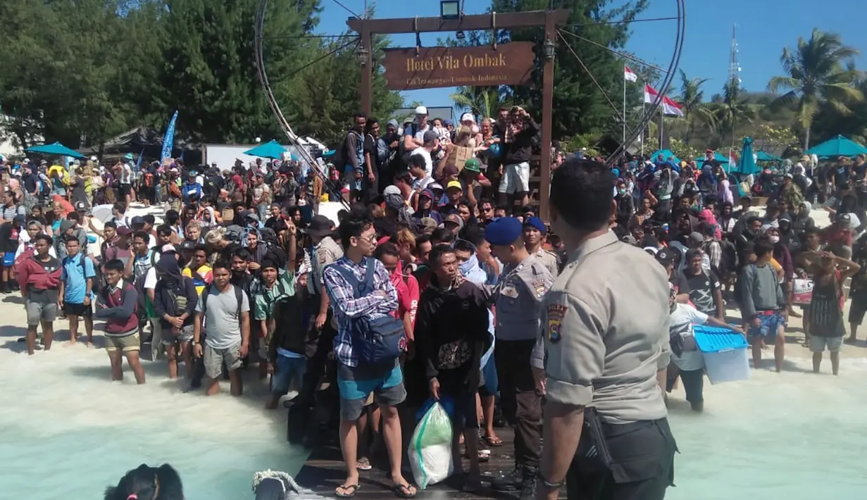 Polisi mengatur saat ratusan orang berusaha meninggalkan Gili Trawangan, NTB, Senin (6/8). Evakuasi dilakukan secara bertahap menggunakan perahu karet menuju kapal yang sudah disiapkan Basarnas. (Handout/Indonesia Water Police/AFP)