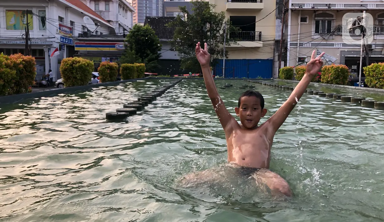 Seorang anak berenang di kolam penghias taman Pasar Baru di Jakarta, Rabu (2/9/2020). Meskipun terdapat larangan, namun sejumlah anak tetap nekat berenang di kolam tersebut sehingga mengganggu ketertiban umum. (Liputan6.com/Immanuel Antonius)