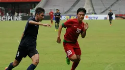 Pemain belakang timnas U-19 Singapura, Hairyl Muhaimin bin Abdul Rahim (kiri) berusaha menghalangi pergerakan penyerang timnas U-19 Indonesia, Justin Stephen saat berlaga di Stadion GBK Jakarta, (8/12/2014). (Liputan6.com/Helmi Fithriansyah)