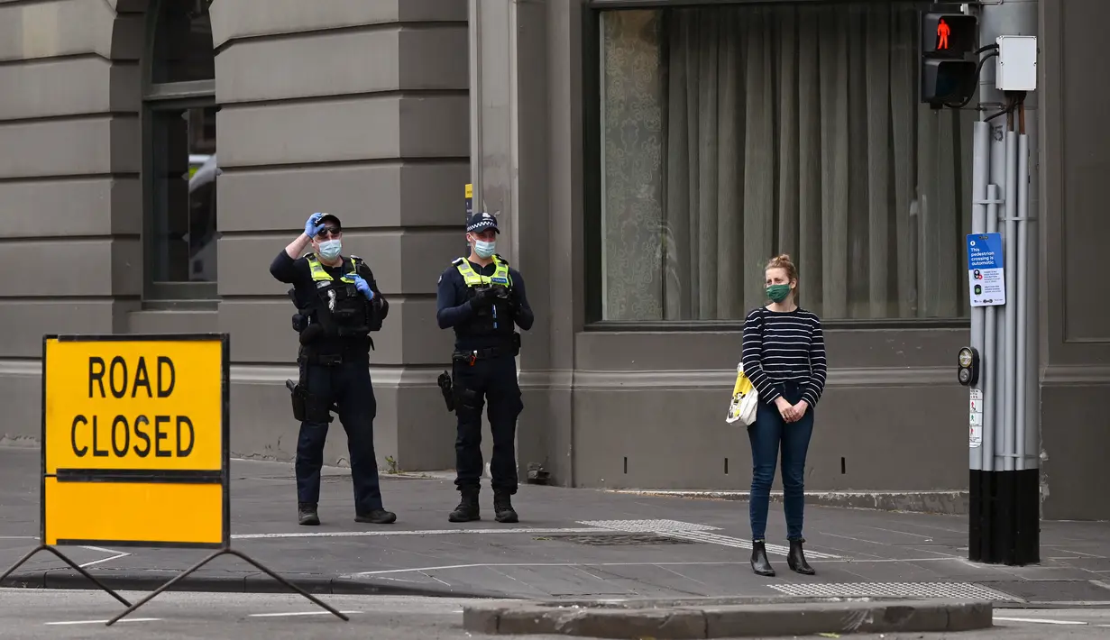Polisi berpatroli di jalan-jalan di Melbourne, Australia, Kamis (30/9/2021). Melbourne bergulat dengan lonjakan infeksi Covid-19 di mana sebanyak 1.438 kasus dilaporkan, jumlah harian terbesar sejak awal pandemi. (William WEST / AFP)