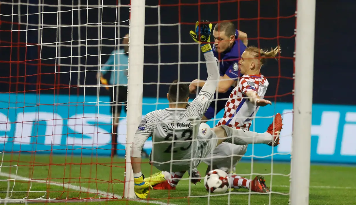 Kiper Kroasia, Danijel Subasic dan rekannya, Domagoj Vida berusaha menggagalkan tendangan pemain Yunani, Kyriakos Papadopoulos pada leg pertama playoff Piala Dunia 2018 di Stadion Maksimir, Jumat (10/11). Kroasia menang 4-1. (AP/Darko Bandic)