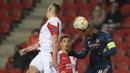 Striker Arsenal, Alexandre Lacazette (kanan) berduel udara dengan bek Slavia Praha, Tomas Holes dalam laga leg kedua perempatfinal Liga Europa 2020/2021 di Sinobo Stadium, Praha, Kamis (15/4/2021). Arsenal menang 4-0 atas Slavia Praha. (AFP/Michal Cizek)