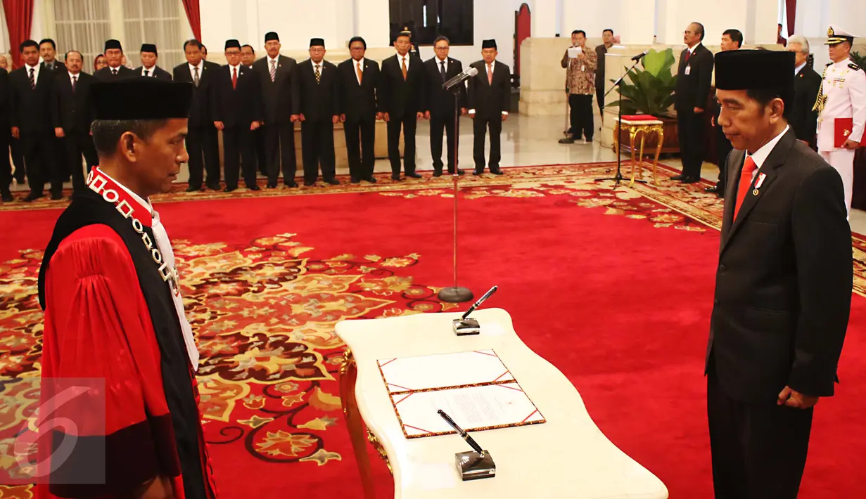 Hakim MK, Saldi Isra disaksikan Presiden Joko Widodo sebelum menandatangani dokumen pelantikan sebagai Hakim MK di Istana Negara, Jakarta, Selasa (11/4). Saldi Isra menggantikan Patrialis Akbar. (Liputan6.com/Angga Yuniar)