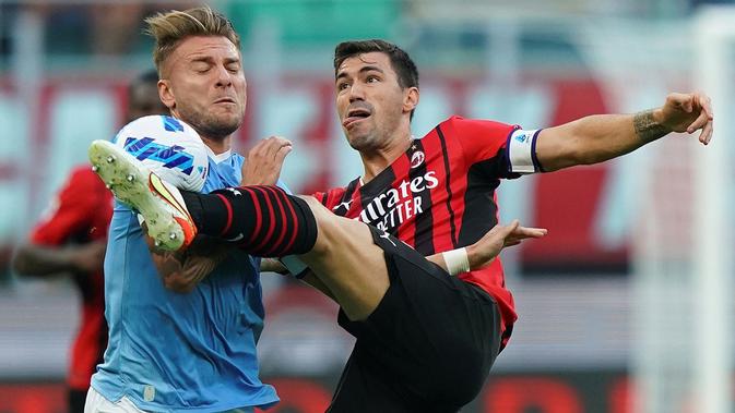 Kapten AC Milan, Alessio Romagnoli, berduel dengan striker Lazio, Ciro Immobile, pada laga pekan ketika Serie A di San Siro, Minggu (12/9/2021) malam WIB. Dalam laga itu, Milan menang 2-0 atas Lazio. (Spada/LaPresse via AP)