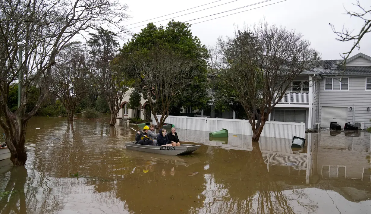 Warga mendayung melalui jalan banjir di Windsor di pinggiran Sydney, Australia, Selasa (5/6/2022). Ratusan rumah terendam di dalam dan sekitar kota terbesar Australia itu dalam keadaan darurat banjir yang berdampak pada 50.000 orang, kata para pejabat. (AP Photo/Mark Baker)