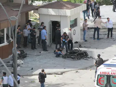 Petugas saat memeriksa lokasi ledakan bom yang menewaskan seorang perwira polisi di dekat kawasan perbatasan Turki dengan Suriah, Minggu (1/5). Peristiwa ledakan tersebut itu telah melukai 13 orang. (REUTERS/Murad Sezer)