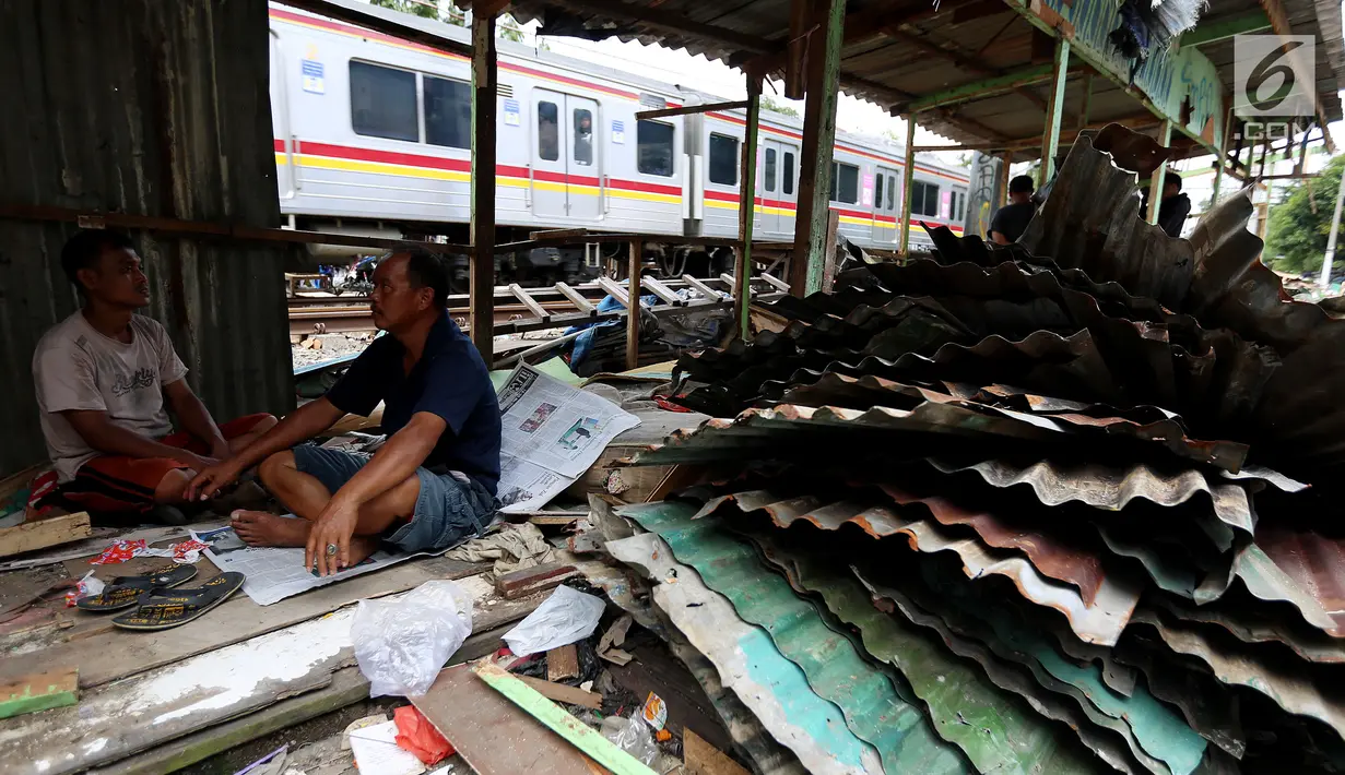 Warga berbincang didekat bongkaran rumah di area Rusun Bendungan Hilir (Benhil) II, Jakarta, Minggu (3/12). Bangunan liar tersebut dibongkar karena berdiri di atas lahan PT Kereta Api Indonesia (PT KAI). (Liputan6.com/JohanTallo)