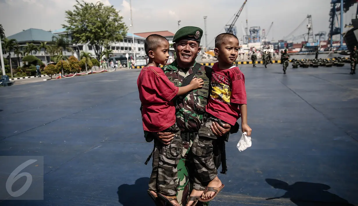 Salah satu personel TNI-AD menggendong anak kembarnya di Pelabuhan Kolinlamil, Jakarta, Senin (9/5). Sebanyak 450 personel TNI-AD dari Satgas Yonif Para Raider 330 inf 1 Kostrad dilepas untuk misi pengamanan perbatasan RI-PNG. (Liputan6.com/Faizal Fanani)
