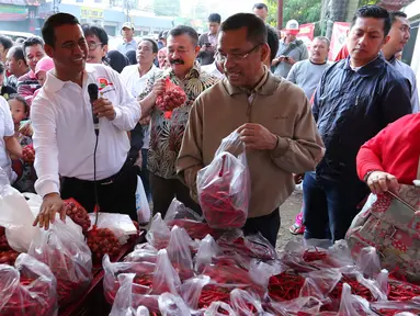 Menteri Pertanian Amran Sulaiman bersama dengan Menteri Perindustrian Saleh Husin saat meninjau oprasi pasar murah di Jakarta, Minggu (12/6). (Liputan6.com/Angga Yuniar)