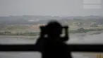 Seorang pengunjung menggunakan teropong untuk melihat sisi Korea Utara dari observatorium unifikasi di Paju, Korea Selatan, Kamis (12/5/2022). Korea Utara memberlakukan lockdown nasional usai mengkonfirmasi kasus COVID-19 untuk pertama kalinya. Kasus subvarian Omicron BA.2 itu terdeteksi di Pyongyang. (AP Photo/Lee Jin-man)