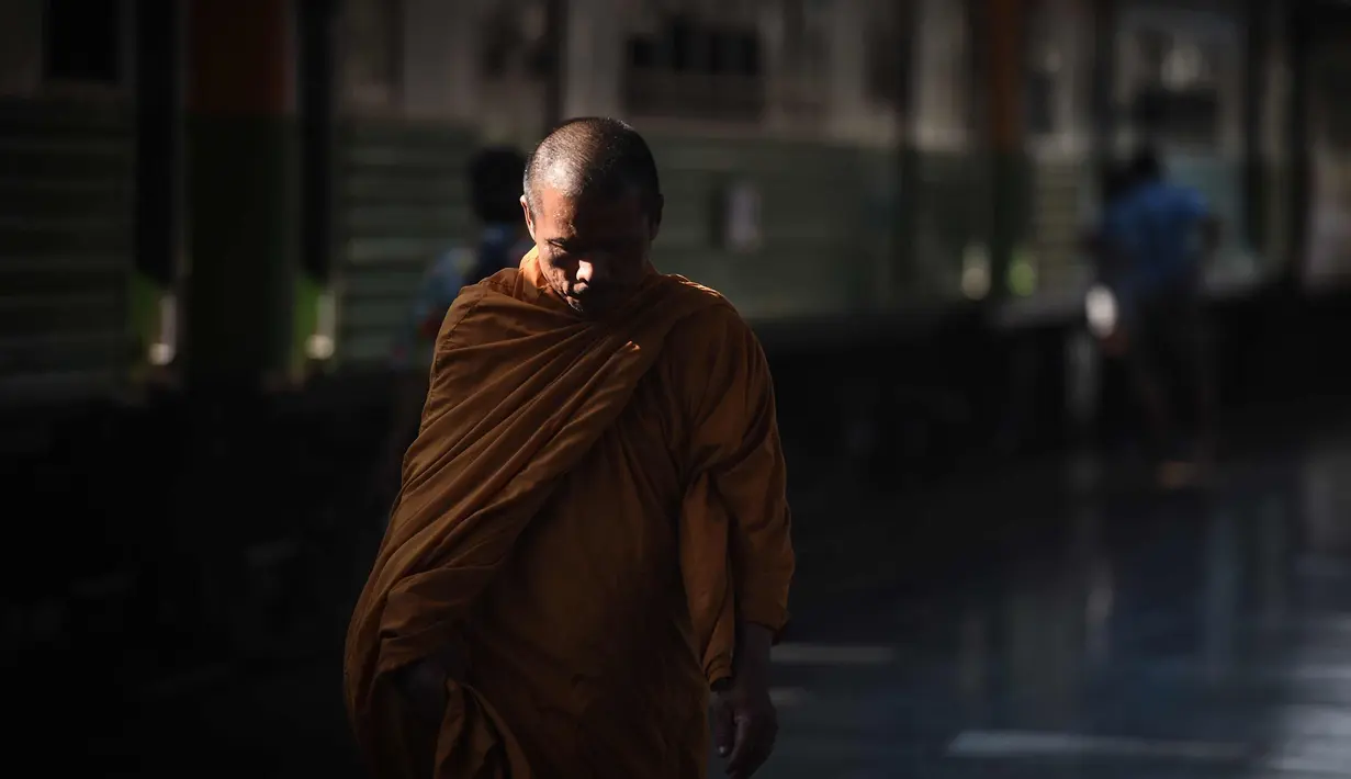 Seorang biksu Buddha berjalan di sepanjang platform kereta api di stasiun kereta api Hua Lampong, sehari sebelum Songkran Festival, atau Tahun Baru Thailand, di Bangkok (12/4). (AFP Photo/Lillian Suwanrumpha)
