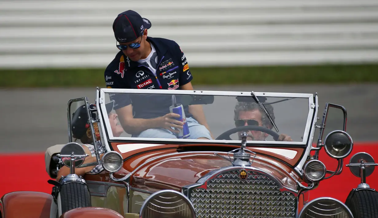 Pembalap Formula Satu dari tim Red Bull, Sebastian Vettel, saat berparade mengelilingi Sirkuit Hockenheim menggunakan mobil antik, (20/7/2014). (REUTERS/Michael Dalder) 