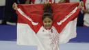 Pesenam Indonesia, Rifda Irfanaluthfi, berpose dengan bendera usai bertanding pada SEA Games 2019 di Kompleks Rizal Memorial, Manila, Senin (2/12). Dirinya berhasil meraih medali perak dari nomor all-round individual putri cabang senam. (Bola.com/M Iqbal