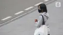 Warga mengenakan masker menanti angkutan umum di Jalan Jenderal Sudirman, Jakarta, Kamis (9/7/2020). Berdasar data yang diumumkan pemerintah pada Kamis (9/7) ada penambahan 2.657 orang yang terinfeksi COVID-19 sehingga jumlah penderita menjadi 70.736. (Liputan6.com/Helmi Fithriansyah)