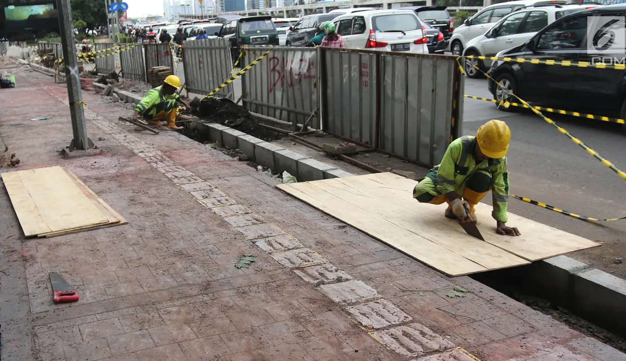 Suasana saat pekerja menggarap proyek penataan jalur pedestrian di Jalan Gatot Subroto, Jakarta, Selasa (13/3). Pemprov DKI menata pedestrian untuk memberi kenyamanan dan keamanan bagi pejalan kaki. (Liputan6.com/Arya Manggala)