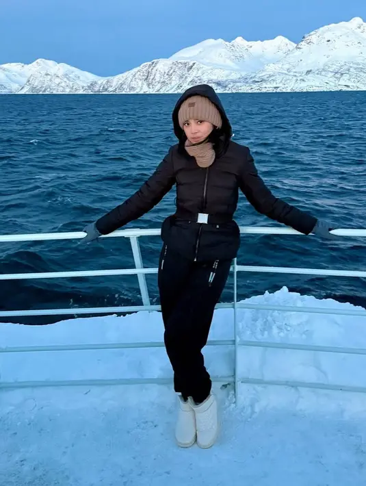 Masih di Norway, Lyodra mengenakan pakaian serba hitam dari jaket padding dan celananya. Dipadukan beanie dan syal coklat.  [@lyodraofficial]
