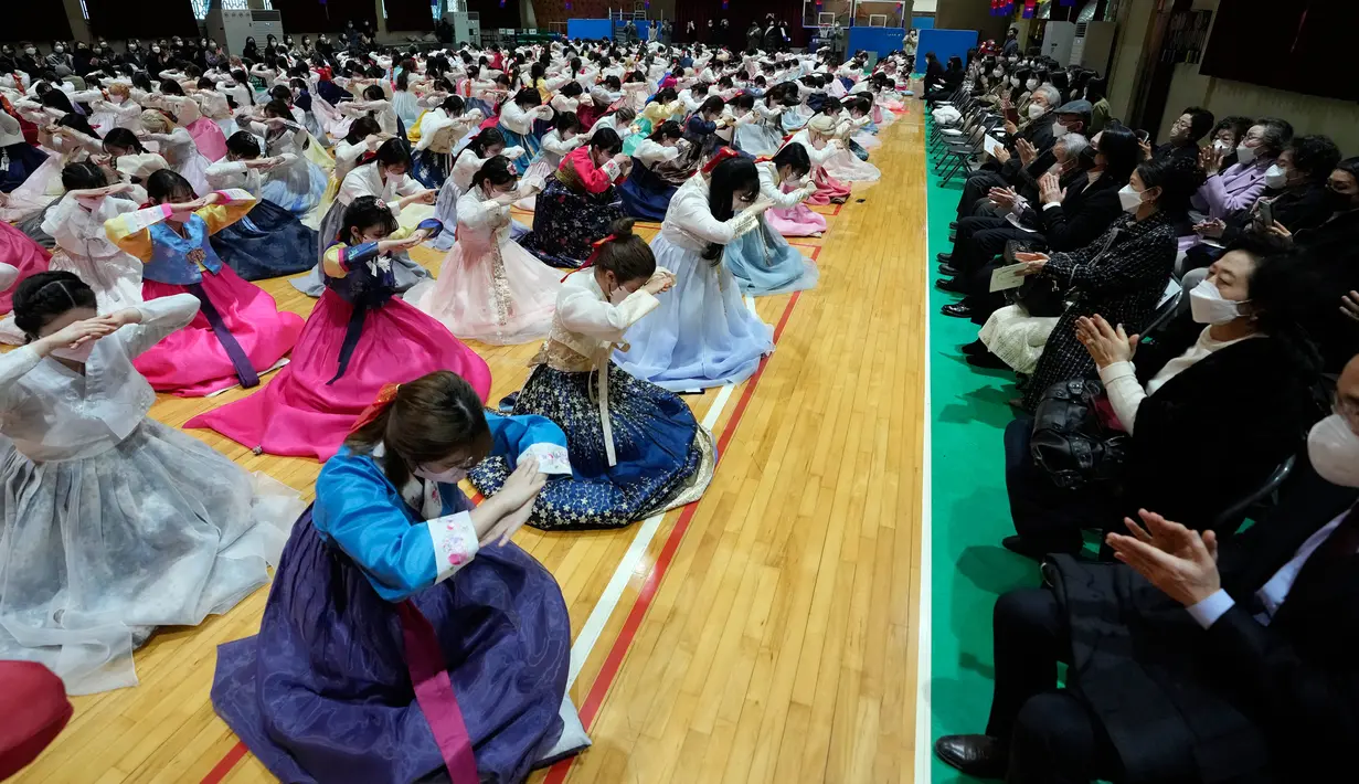 Siswa sekolah menengah atas yang mengenakan pakaian tradisional membungkuk kepada guru dan orangtua mereka saat upacara kelulusan dan kedewasaan bersama di Sekolah Menengah Wanita Dongmyung, Seoul, Korea Selatan, 7 Februari 2023. Sekolah menengah atas di Korea Selatan mengajar siswa selama tiga tahun, dari kelas satu (usia 15–16) hingga kelas tiga (usia 17–18), dan siswa biasanya lulus pada usia 17 atau 18 tahun. (AP Photo/Ahn Young-joon)