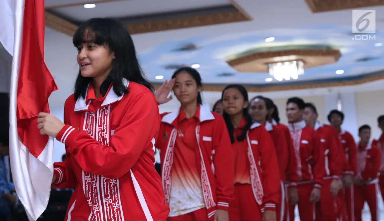 Salah satu atlet pelajar Indonesia untuk Asian School Games 2018 mencium bendera Merah Putih saat upacara pelepasan di Wisma Kemenpora, Jakarta, Selasa (17/7). Asian School Games 2018 berlangsung 19-27 Juli di Malaysia. (Liputan6.com/Helmi Fithriansyah)