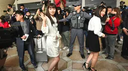 Dua anggota girlband K-pop "Red Velvet" menyapa awak media sebelum berangkat ke Pyongyang dari Bandara Internasional Gimpo di Seoul (31/1). Mereka akan tampil dalam rangka pertunjukan lintas budaya menjelang pertemuan tingkat tinggi.  (Jung Yeon-je / AFP)
