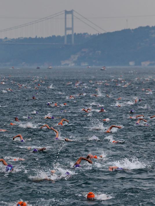 Ratusan atlet renang mengikuti lomba renang dari Asia hingga Eropa di Selat Bosphorus ke-30, Istanbul, Turki, (22/7). Lebih dari 2.000 peserta terjun dari feri dan berenang sejauh sekitar 6,5 km di acara tersebut. (AP Photo/Lefteris Pitarakis)