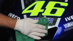 Pekerja membersihkan motor milik pebalap MotoGP asal Itali, Valentino Rossi. Bersama Yamaha, juara dunia sembilan kali itu menggunakan motor dengan dominasi warna biru. (AFP Photo/Radek Mica)