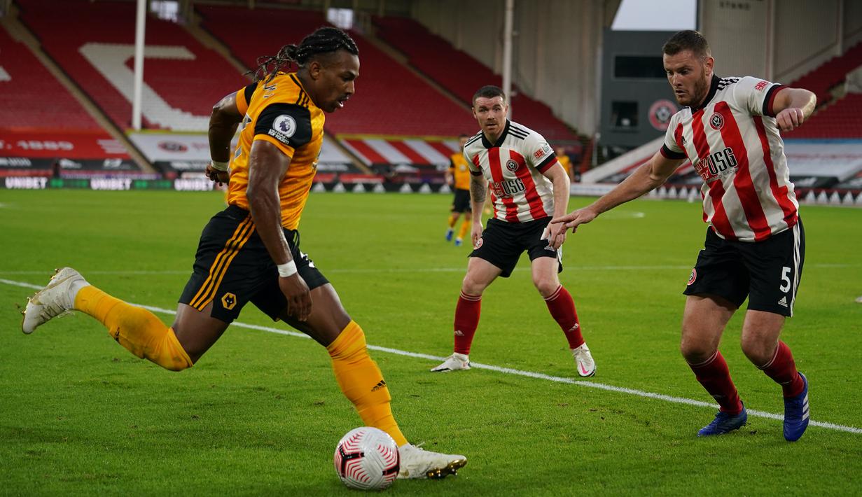 Gelandang Wolverhampton Wanderers, Adama Traore, berebut bola dengan bek Sheffield United, Jack O'Connell, pada laga Liga Inggris di Bramall Lane, Selasa (15/9/2020). Wolverhampton menang 2-0 atas Sheffield United. (AFP/Dave Thompson/pool)
