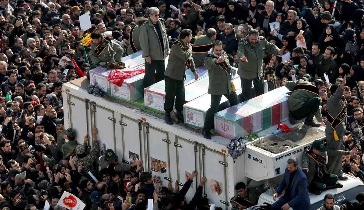 Peti mati Jenderal Qasem Soleimani dan sejumlah orang yang tewas dalam serangan Amerika Serikat dikelilingi pelayat di Teheran, Iran, Senin (6/1/2020). Prosesi pemakaman Soleimani digelar di berbagai kota secara berurutan sejak akhir pekan. (AP Photo/Ebrahim Noroozi)