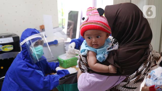 FOTO: Berikan Imunisasi, Bidan di Tangerang Kenakan APD Lengkap