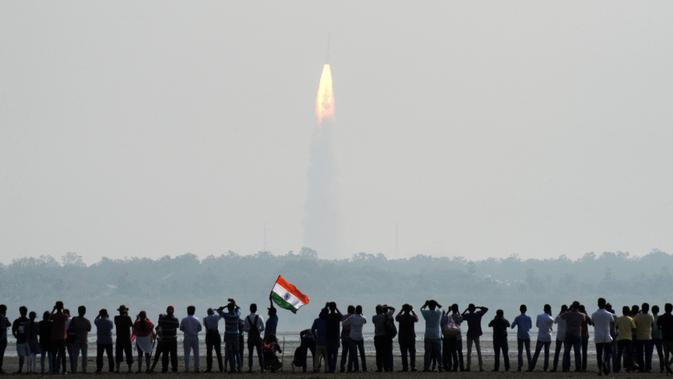Warga India melihat peluncuran 104 satelit dalam satu misi di pusat antariksa Sriharikota di India timur, Rabu (15/2). Keberhasilan ini membuat India menciptakan rekor dunia dalam peluncuran satelit. (AFP PHOTO/ ARUN SANKAR)