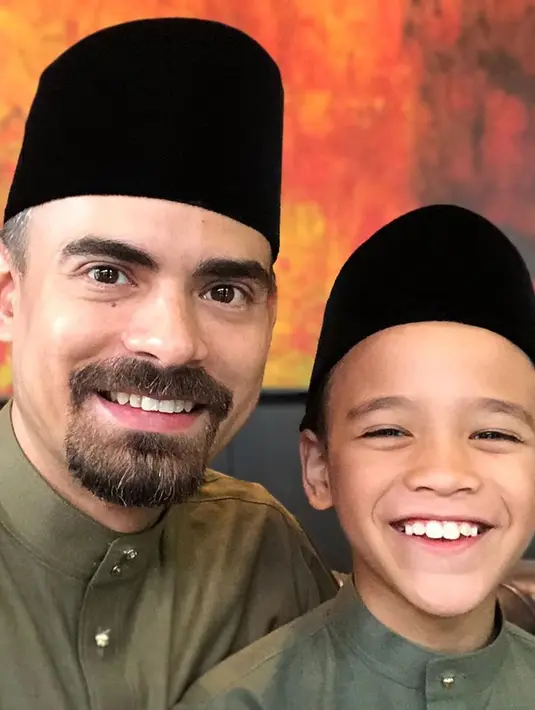 Suami Bunga Citra Lestari, Ashraf Sinclair dan putranya Noah Aidan Sinclair berpose dengan mengenakan busana serasi dan peci hitam. Ashraf Sinclair dimakamkan di San Diego Hills, Karawang, Jawa Barat. (Instagram/@ashrafsinclair)