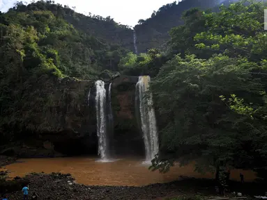 Wisatawan mengambil gambar curug Sodong Kembar di kawasan Ciletuh Geopark, Sukabumi, Sabtu (23/6). Tempat ini kian populer karena keindahan alamnya dan batuan alamnya yang dihadirkan di setiap obyek wisata di Geopark Ciletuh. (Merdeka.com/Arie Basuki)