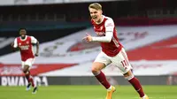 Pemain Arsenal, Martin Odegaard, melakukan selebrasi usai mencetak gol ke gawang Tottenham Hotspur pada laga Liga Inggris di Stadion Emirates, Minggu (14/3/2021). Arsenal menang dengan skor 2-1. (Dan Mullan/Pool via AP)