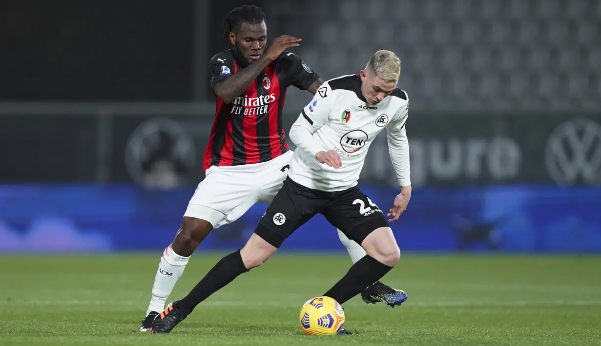 Gelandang AC Milan, Franck Kessie berusaha merebut bola dari gelandang Spezia, Nahuel Estevez pada pertandingan Liga Serie A Italia di stadion Alberto Picco, Italia, Minggu (14/2/2021). Kemenangan ini membuat Spezia bercokol di posisi ke-14 dengan koleksi 24 angka. (Spada/LaPresse via AP)