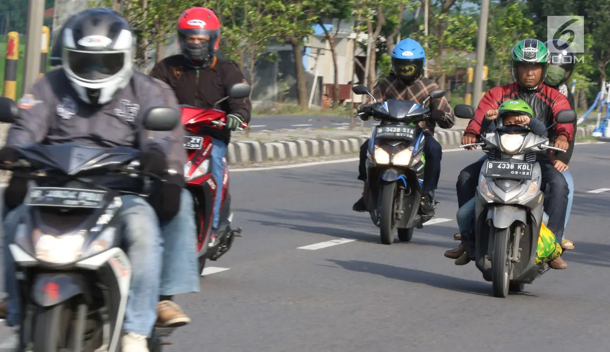 Pemudik sepeda motor dengan membawa anak melintasi Jalur Pantura Cirebon, Jawa Barat, Kamis, (29/6). Memasuki H+4 Lebaran jalur Pantura Cirebon mengarah ke Jakarta mulai dipadati pemudik pengguna kendaraan bermotor roda dua (Liputan6.com/Helmi Afandi)