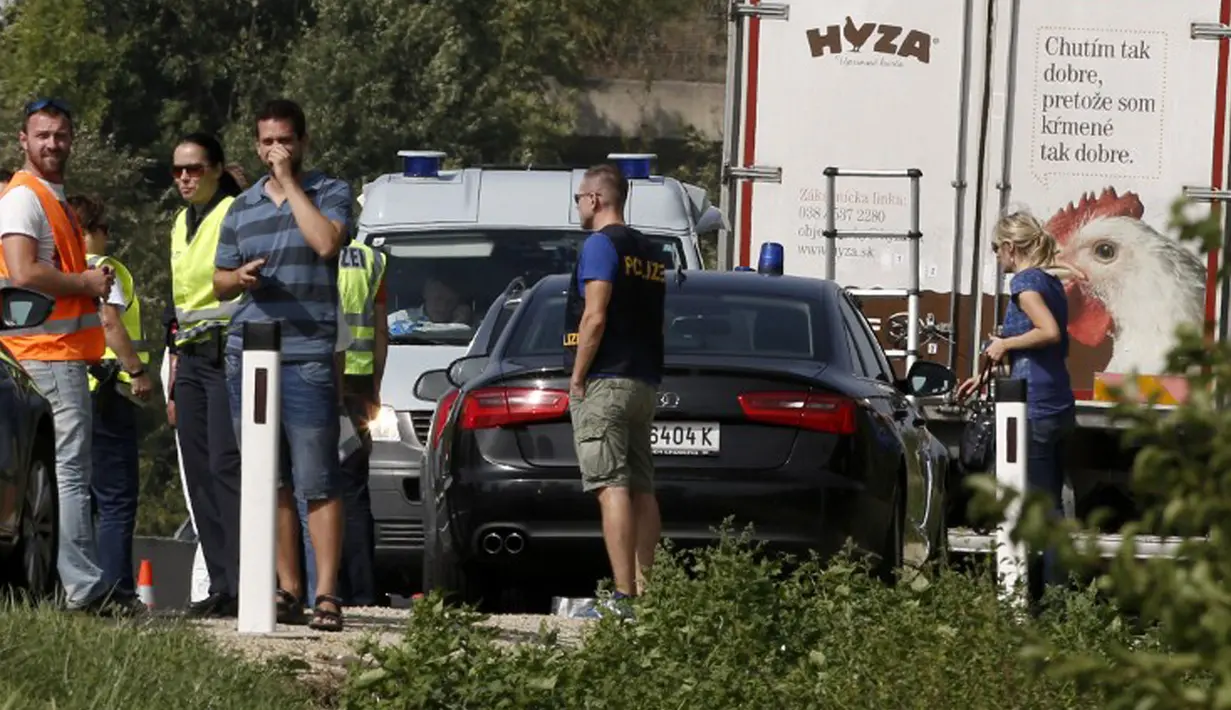 Polisi berada di lokasi dimana sebuah truk yang berisi sekitar 50 imigran gelap yang tewas terparkir di jalan tol di Austria, dekat perbatasan Hongaria, Kamis (27/8/2015). Indikasi awal mereka tewas karena kekurangan oksigen. (AFP PHOTO/Dieter NAGL)