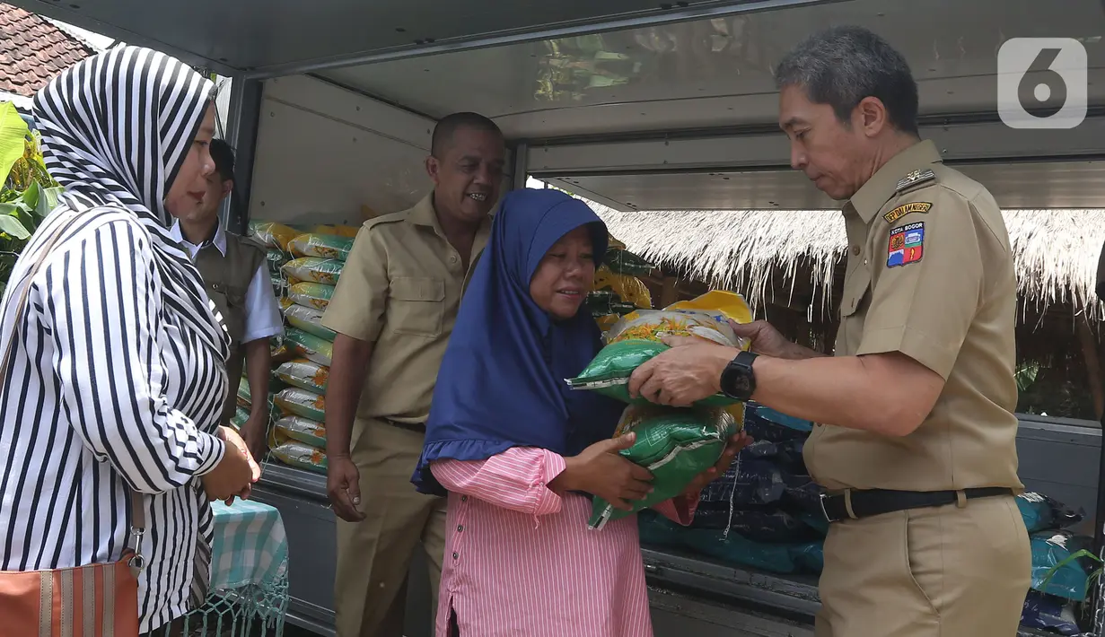 Wakil Wali Kota Bogor, Dedie A. Rachim menyerahkan beras untuk stabilisasi pasokan dan harga pangan (SPHP) seharga Rp53 ribu/5 kg saat kegiatan Operasi Pasar Bulog Siaga di kawasan Mulyaharja, Bogor, Senin (4/3/2024). (merdeka.com/Arie Basuki)