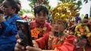 Murid TK Sekolah Alternatif untuk Anak Jalanan (SAAJA) ber-selfie dengan mengenakan pakaian adat di kawasan Kuningan, Jakarta, Selasa (21/4/2015). Kegiatan tersebut dalam rangka Hari Kartini yang diperingati setiap 21 April. (Liputan6.com/Faizal Fanani)