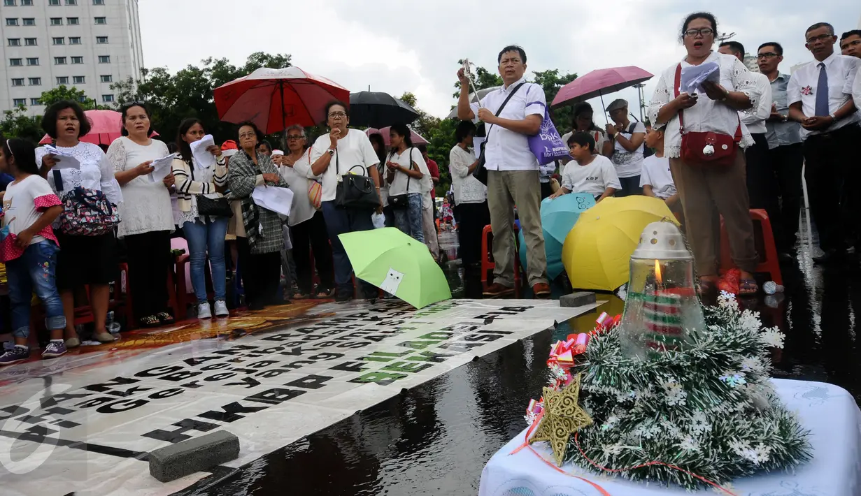 Jemaat GKI Yasmin Bogor dan HKBP Filadelfia Bekasi melakukan misa perayaan Natal 2016 di Silang Barat Laut Monas, Jakarta, Minggu (25/12). Mereka berharap pemerintah turun tangan karena gereja mereka masih disegel. (Liputan6.com/Helmi Fithriansyah)