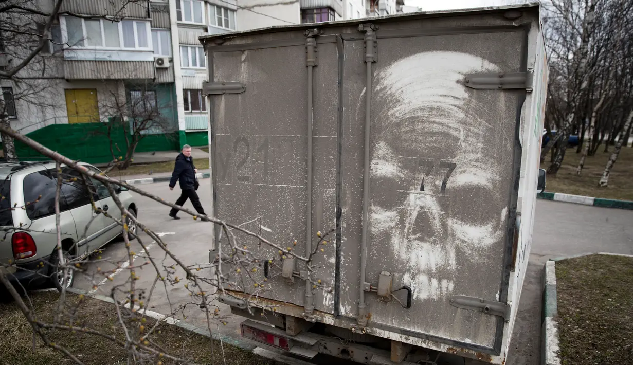 Sebuah truk kotor disulap menjadi lukisan tengkorak oleh Nikita Golubev di Moskow, Sabtu (22/4). Golubev menggunakan truk dan van yang kotor dan berdebu untuk menciptakan karya seninya. (AP Photo / Pavel Golovkin)