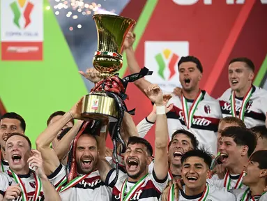 Pemain Bologna merayakan kemenangan dengan mengangkat trofi Piala Italia (Coppa Italia) usai mengalahkan AC Milan pada laga final yang digelar di stadion Olimpico, Roma, pada 14 Mei 2025 waktu setempat atau pada Kamis (15/5/2025) dini hari WIB. (Isabella BONOTTO/AFP)