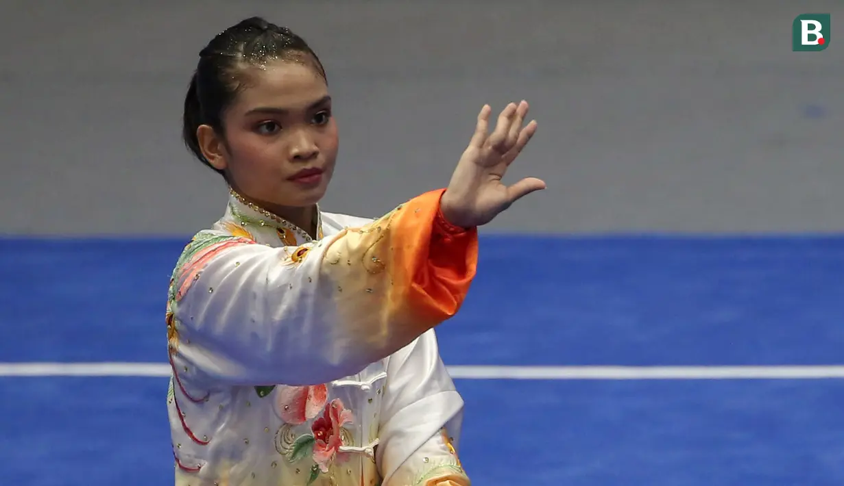 Atlet Wushu Indonesia, Alisya Mellynar saat bertanding dalam cabang olahraga Wushu nomor Taolu Tajiquan Wanita SEA Games 2021 yang berlangsung di Cau Giay Gymnasium, Hanoi, Sabtu (14/5/2022). Ia berhasil meraih medali emas setelah mengumpulkan skor 9,71. (Bola.com/Ikhwan Yanuar)