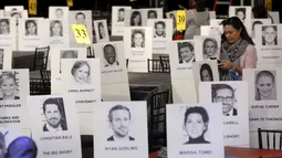 Seorang wanita berdiri diantara deretan tempat duduk  yang disertai foto para selebriti dan tamu saat persiapan jelang Screen Actors Guild Awards 2016 di Shrine Auditorium, Los Angeles, Jumat (29/1). (REUTERS/Mario Anzuoni)