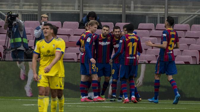 Para pemain Barcelona merayakan gol Lionel Messi ke gawang Cadiz dalam lanjutan Liga Spanyol di Camp Nou, Minggu (21/2/2021). (AP Photo/Joan Monfort)